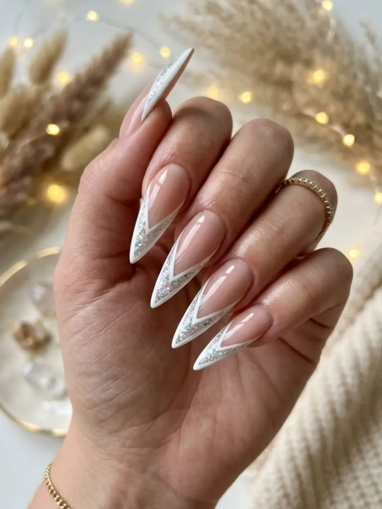 Nude stiletto nails with V-shaped glitter French tips for an elegant 30th birthday party look